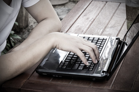 Person Typing on a modern laptop in coffee shop. Soft focus.の写真素材