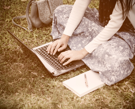 Young girl using laptop in park - Soft focusの写真素材