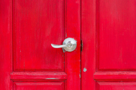 Old red wooden door with metal handle.の写真素材