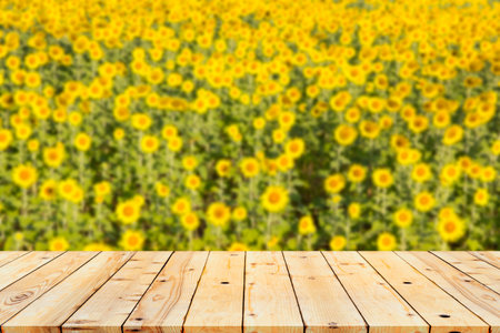 Wood table top on blurred background of  sunflowers.