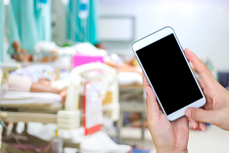 hand using smart phone black screen on blurred hospital background.の写真素材