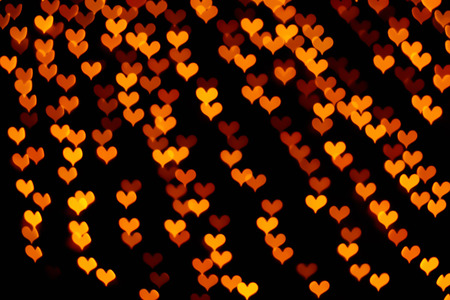 Colorful hearts bokeh on a dark background, orange heart bokeh.の写真素材