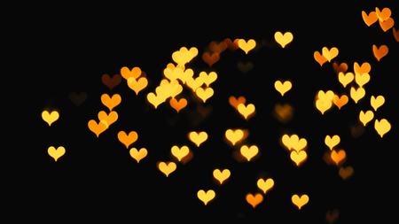 Colorful hearts bokeh on a dark background, orange heart bokeh.の写真素材