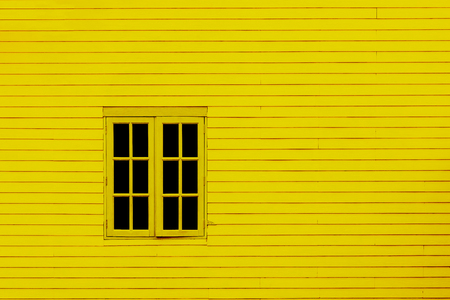 Old window of yellow wooden house wallの写真素材