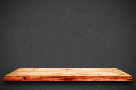 Empty wooden shelf on black gradient background. For display or montage your products.の写真素材