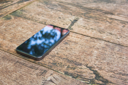 Moblie smart phone on wood table backgroundの写真素材