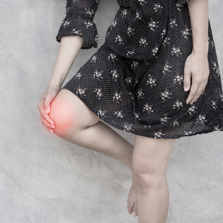 Female holding hand on spot knee pain.の写真素材