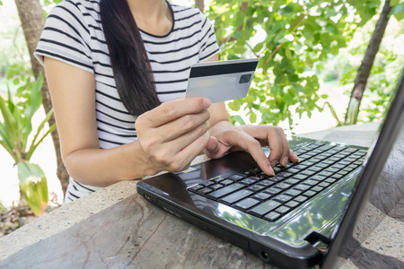 Hands holding credit card and using laptop for online shopping.の写真素材