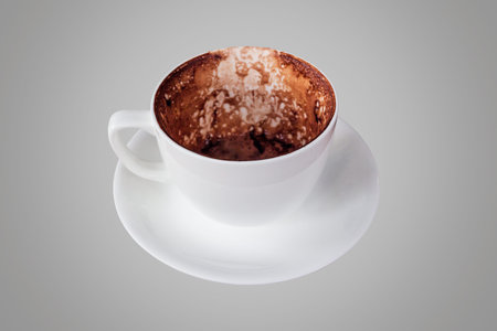 Empty hot coffee cup after drink isolated on grey background.