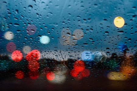Raindrop on window with the rainy night city