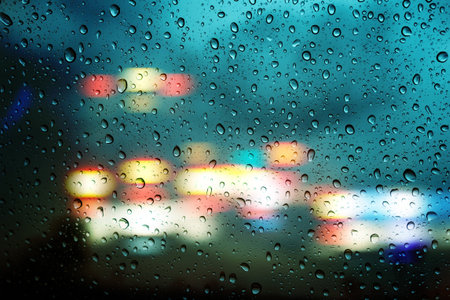 Raindrop on window with the rainy night city