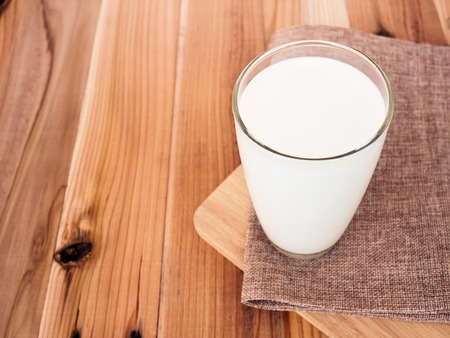 Milk glass on wood table background.の写真素材