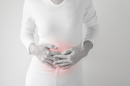 Middle-aged woman stomachache on gray wall background.の写真素材