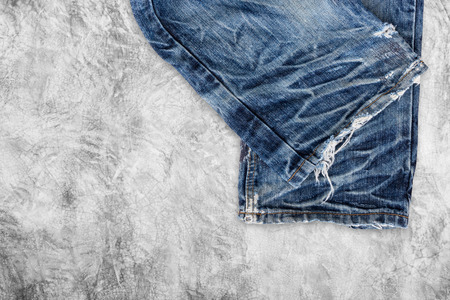 Blue jeans on concrete floor background.の写真素材