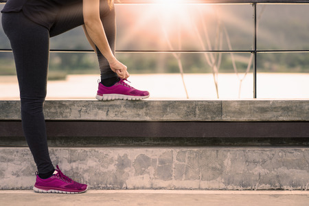 Young woman is running in sunny nature background.の写真素材