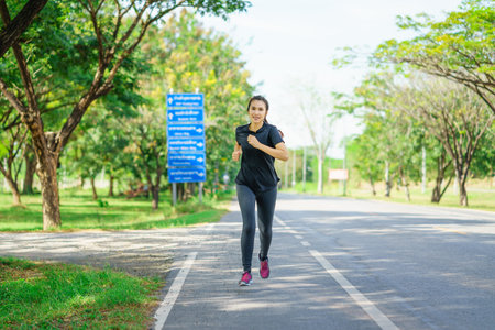 Young asian woman jogging in nature park