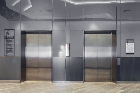 Front view of modern elevator with closed doors in lobbyの写真素材