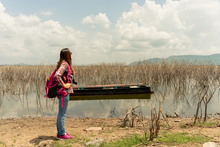 Young traveler woman staying on the lake in summer time.の写真素材