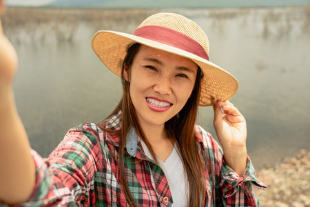 Traveler young woman taking selfie at the lake in summer time.の写真素材