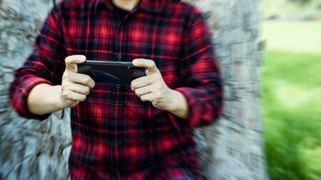 Man playing game on smartphone.の写真素材