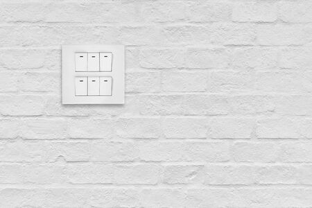 light switch on white brick wall background.の写真素材