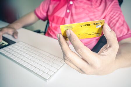Man paying with credit cards on computer at home.の写真素材