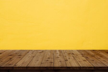 Wooden table top on yellow wall background.の写真素材