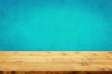 Empty top of wood table with a blurred blue wall background.の写真素材