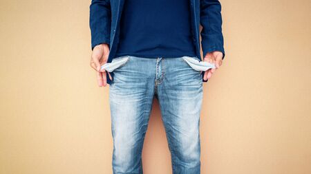 Man showing his empty pockets on cement wall background, Impact of epidemics Coronavirus (COVID-19).の写真素材