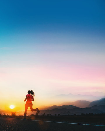 Young fitness Asian woman is running and jogging an outdoor workout on the road in the morning for...
