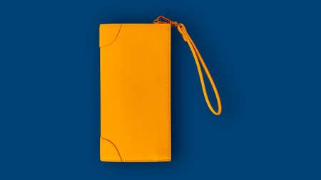 Top view of a yellow lady wallet on a blue background.の写真素材