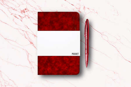 Blank red paper notebook or pocket book and a pen on white marble table background.の写真素材