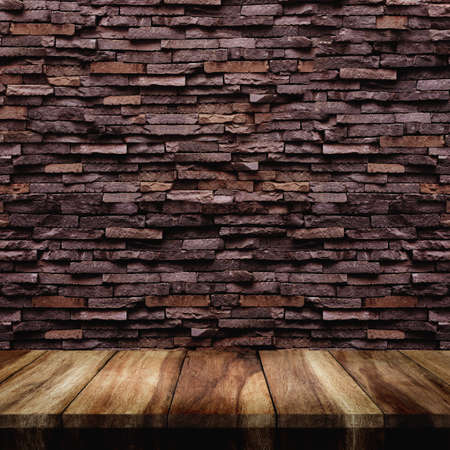 Empty top of old wood table with stone wall texture for background.の写真素材