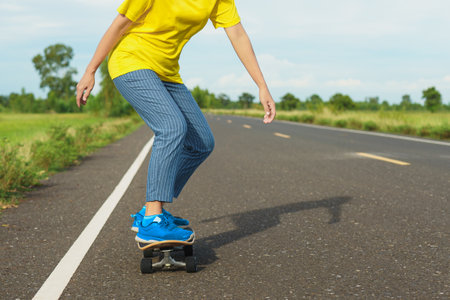 Woman on surf skate with road in the countryside.の写真素材