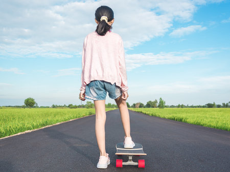 Girl on surf skate with road in the countryside.の写真素材
