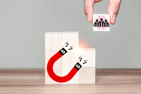 Hand put wooden cubes with businessman team to a big magnet. Concept of making money, successful...