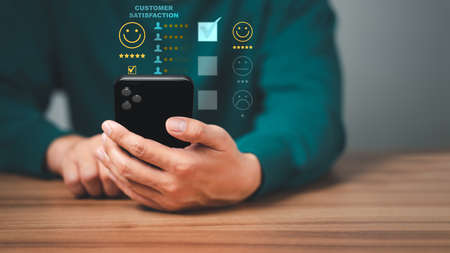 Man using a mobile phone in give rating to service experience on application. Online customer review satisfaction feedback survey.の写真素材
