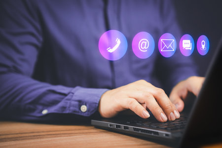 Businessman using a computer laptop with the call phone, email, address, chat message and map icons. Customer support hotline contact us people connection concept.の写真素材
