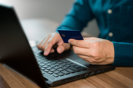 Man uses a laptop to register through a credit card to make online purchases. Credit card safe online shopping and payment concept.の写真素材
