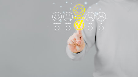 Man touching the virtual screen on the happy smiley face icon to give satisfaction in service. Rating very impressed. Customer service, testimonial and satisfaction concept.の写真素材