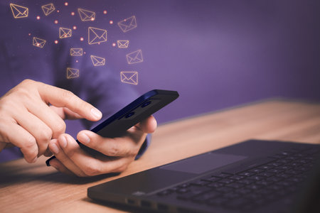 Email Marketing and Newsletters, Technology and lifestyle concepts. Man's hand using smartphone or mobile phone and sending online message with email icon.の写真素材