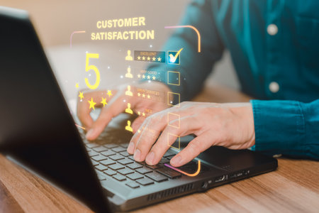 Businessman hand using computer laptop with popup five star icon for feedback review satisfaction service, testimonial. Customer service experience and business satisfaction survey.の写真素材