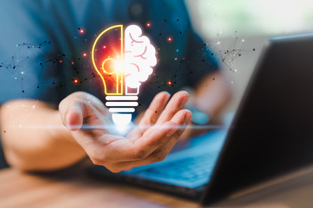 Man holding abstract light bulb icon while working on computer thinking and create new ideas, with technological innovation and creativity Ideas inspired by online technology innovation.の写真素材