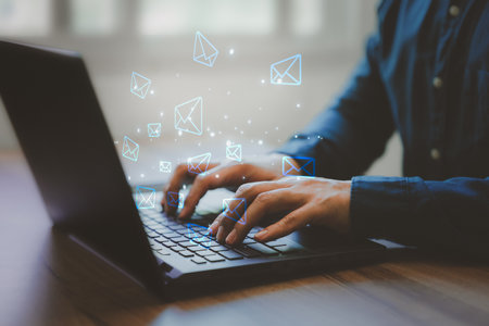 Email Marketing and Newsletters, Technology and lifestyle concepts. Man's hand using computer laptop and sending online message with email icon.の写真素材