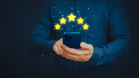 Man's hand using a smartphone and give five star symbol to increase rating of product and service concept, Customer service experience, testimonial and business satisfaction survey.の写真素材