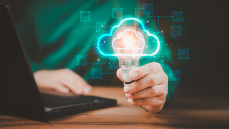 Man holding a light bulb while working on the computer to think and create new ideas. Business global internet connection application technology and digital marketing, Financial and banking.の写真素材