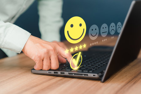 Man hand using computer laptop with popup five star icon for feedback review satisfaction service, testimonial. Customer service experience and business satisfaction survey.の写真素材
