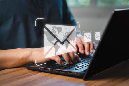 Man's hand using computer laptop and sending online message with email icon, email marketing concept, send email or newsletter, internet network working online.の写真素材