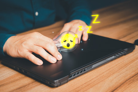Man put a glowing a light bulb wiht sleepy icon on a wooden table, business problem solving ideas and creative marketing ideas Inventing and learning new things.の写真素材