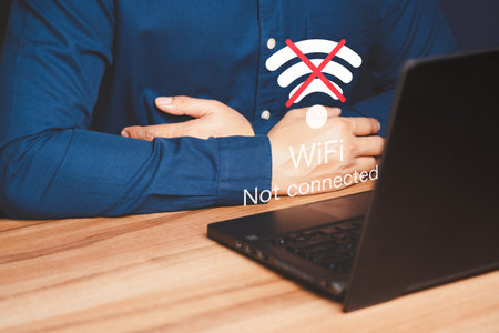 Man using a computer laptop to connect to wifi but wifi not connected, and waiting to loading digital business data form website, concept technology of waiting for connect to wifi.の写真素材